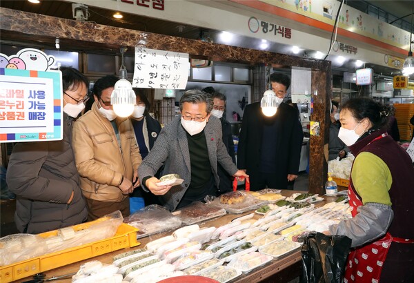 18일 송강전통시장에서 정용래 유성구청장(가운데)이 상인들을 만나고, 직접 장을 보고 있다.