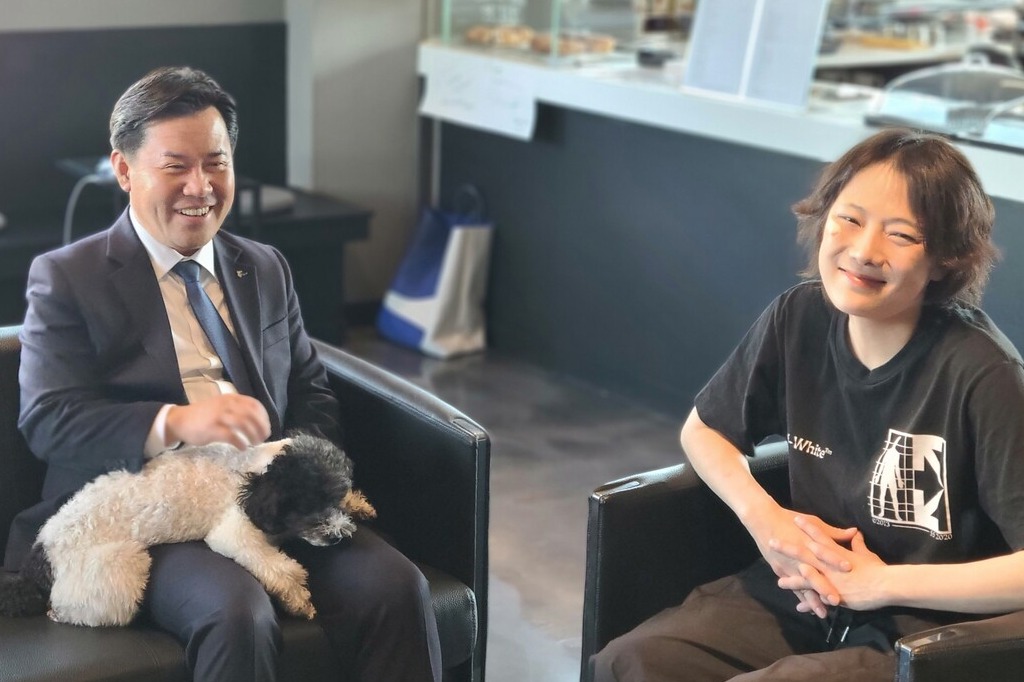 박정현 군수와 김차이씨가 '바이더폰드'의 마스코트인 반려견 오레오를 두고 대화를 나누고 있다. 