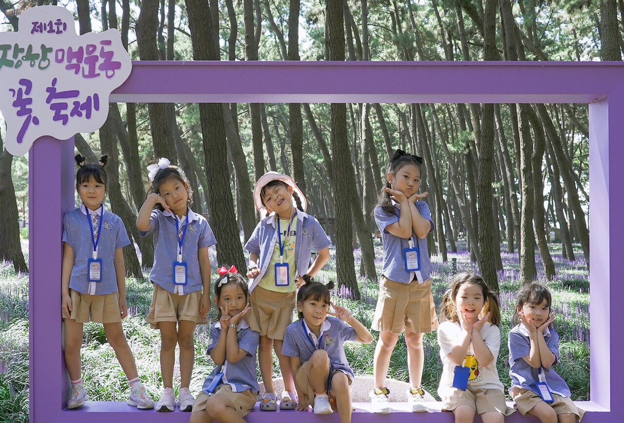 맥문동 솔숲 곳곳에 마련된 포토존에서 아이들이 각자의 포즈를 취하고 있다. 서천군 제공.