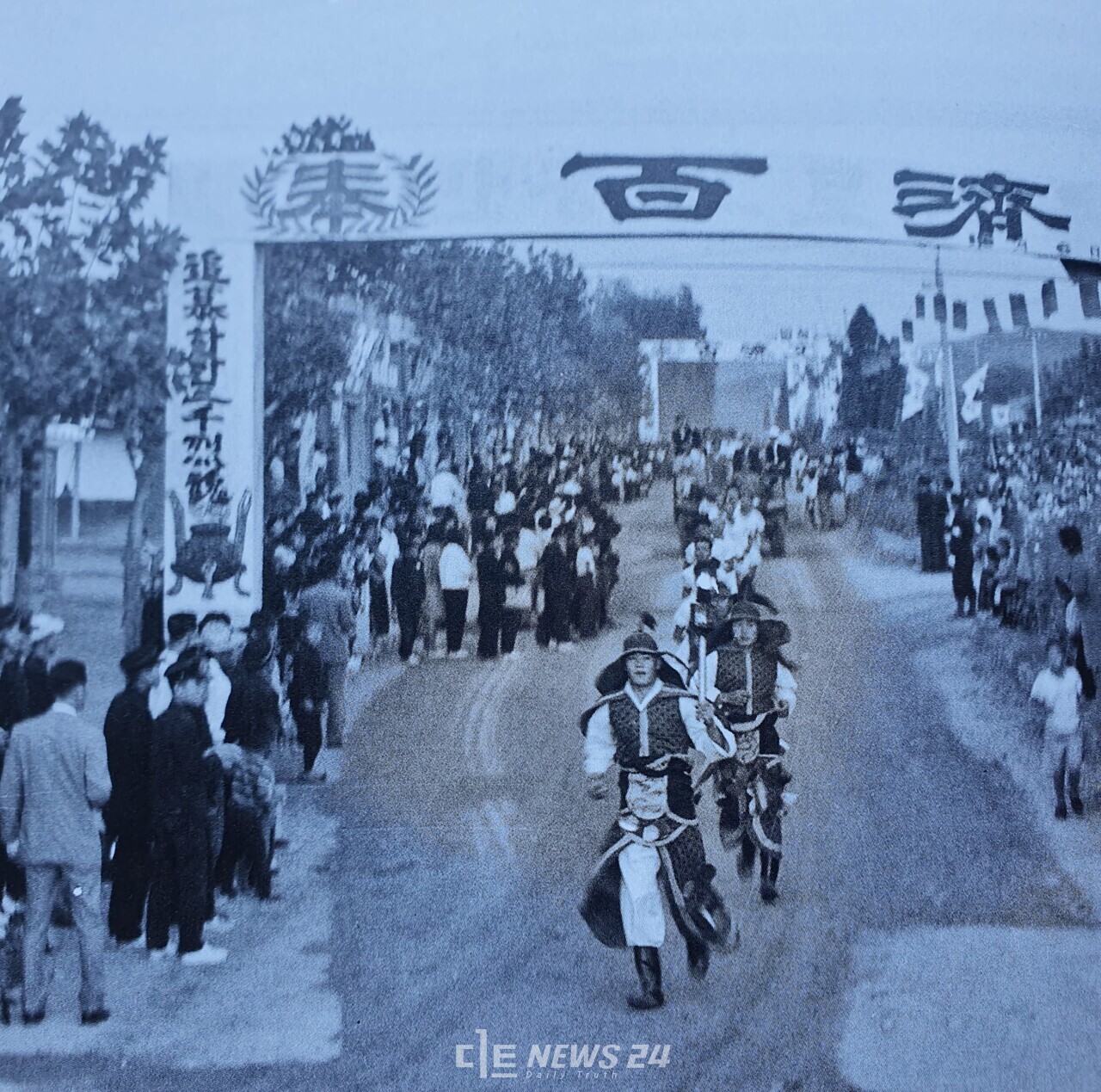 1966년 10월 6일. 100리 길을 달려온 사비성 천도 성화가 부여군민의 환영을 받으며 지금의 성왕로를 지나고 있다. 백제 장군복을 입은 성화 주자 뒤로 부여 시내까지 성화를 봉송했던 주자들이 따라오고 있다. 백제문화제 60주년 기념집 발췌.