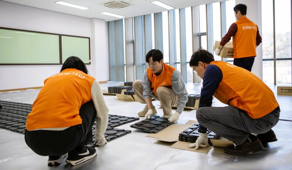 한화토탈에너지스 봉사자들이 플라스틱 원료 온돌매트 설치작업을 하고 있다. 한화토탈에너지스제공.
