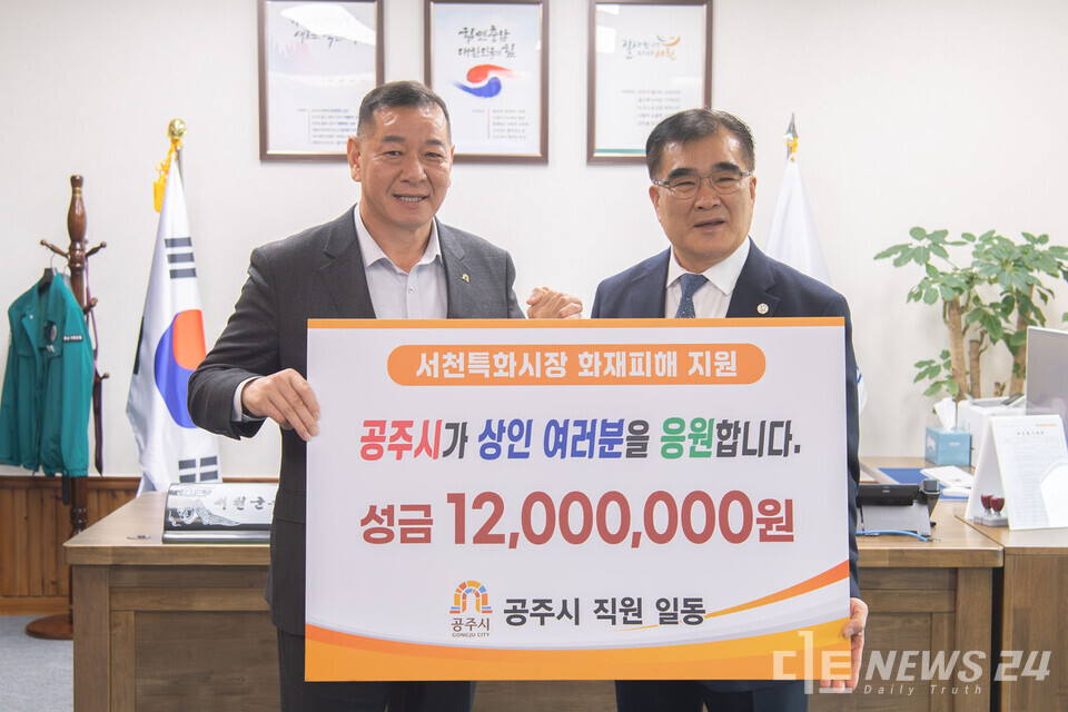 공주시(시장 최원철)는 지난 27일 서천특화시장 화재피해 복구를 지원하기 위해 성금 1200만원을 전달했다. 왼쪽부터 최원철 시장, 오른쪽 김기웅 서천군수. 공주시 제공