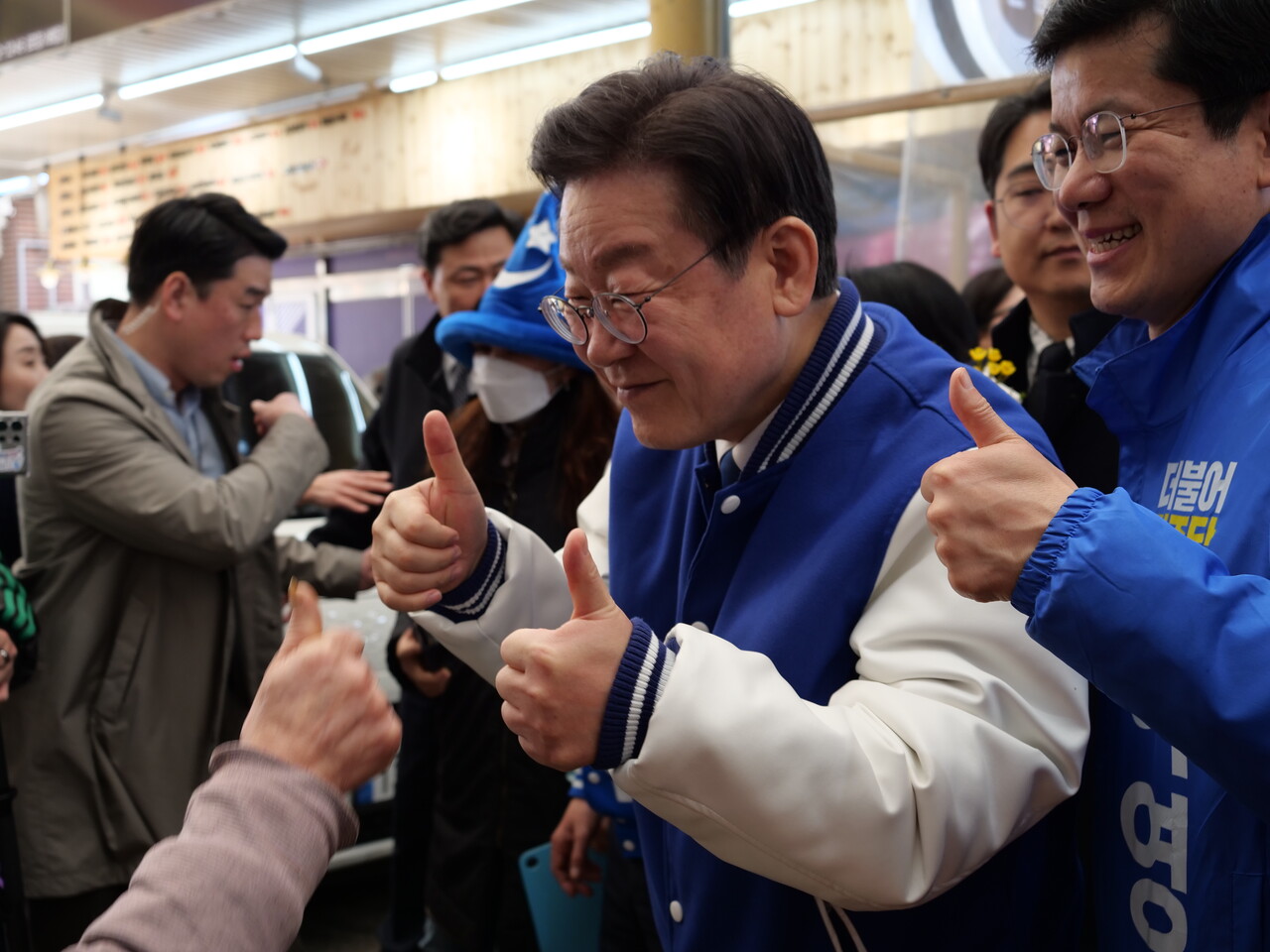 이재명 민주당 대표와 이영선 세종갑 국회의원 예비후보가 지지자인 상인과 함께 두 손가락을 들어올리고 있다. 한지혜 기자.