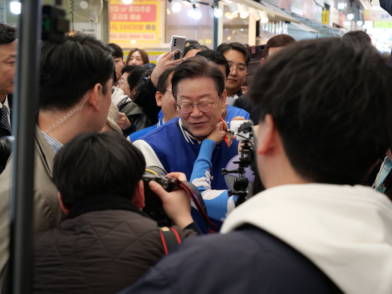 세종전통시장을 찾은 이재명 민주당 대표에게 한 지지자가 목에 스카프를 둘러주고 있다. 한지혜 기자.