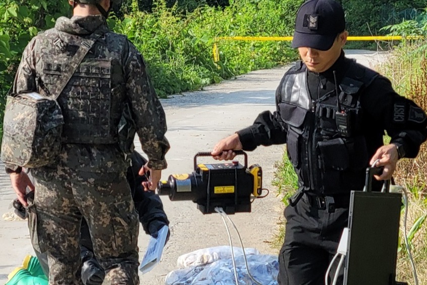 군 관계자들이 2일 오전 6시 부여임천면 일대에서 발견된 오물 풍선을 분석하고 있다. 일반 잡쓰레기로 확인됐다. 독자제공 . 