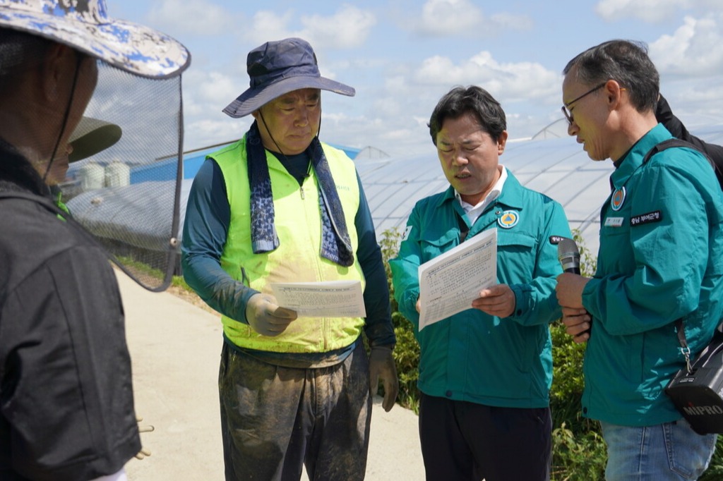 박정현 부여군수가 지난 15일 부여 장암면 피해 농가를 방문한 어기구 의원에게 '농작물재해보험'의 재설계 필요성을 설명하고 있다. 자료사진. 