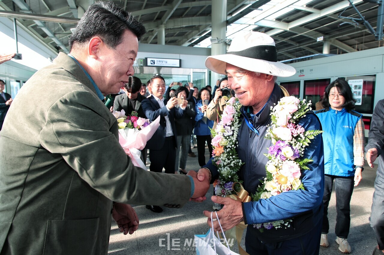 합덕역 첫 방문의 행운은 서해선 개통기념으로 서화성역에서 열차 탑승 후 합덕역에 내린 합덕읍 주민 안모 씨에게 돌아갔다. 오성환 당진시장(왼쪽)이 꽃목걸이를 걸어주고 있다. 당진시