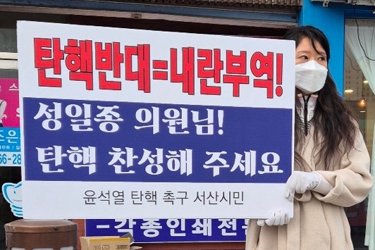 윤석열 대통령의 탄핵을 촉구하는 서산 시민이 서산 시청 앞 성일종 의원 지역 사무실 앞에서 피켓 시위를 하고 있다. 민주당 당협위원회 제공. 