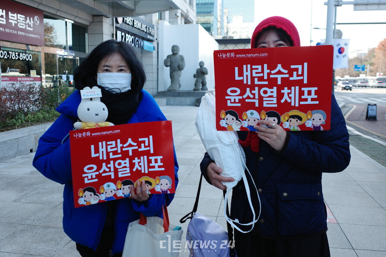 내란수괴 윤석열 체포라는 손팻말을 들고 여의도로 향하는 시민. 황재돈 기자. 
