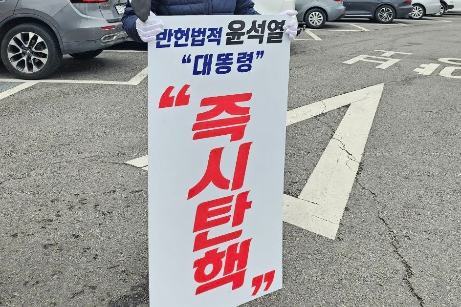 부여군민 D씨가 9일 오전 부여군청 앞에서 '반헌법적 윤석열, 즉시탄핵'이라고 적힌 피켓을 들고 1인 시위에 나섰다. 독자 제공. 