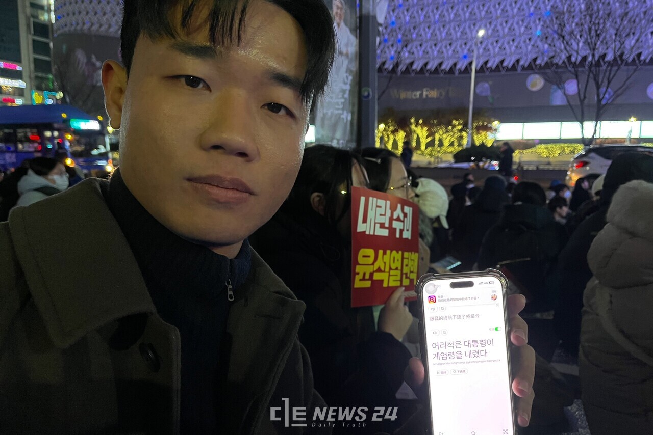 윤석열 탄핵 대전시민대회에 참가한 대만 출신 동빈 씨. 휴대전화 번역기 앱을 통해 소감을 전했다. 유솔아 기자. 