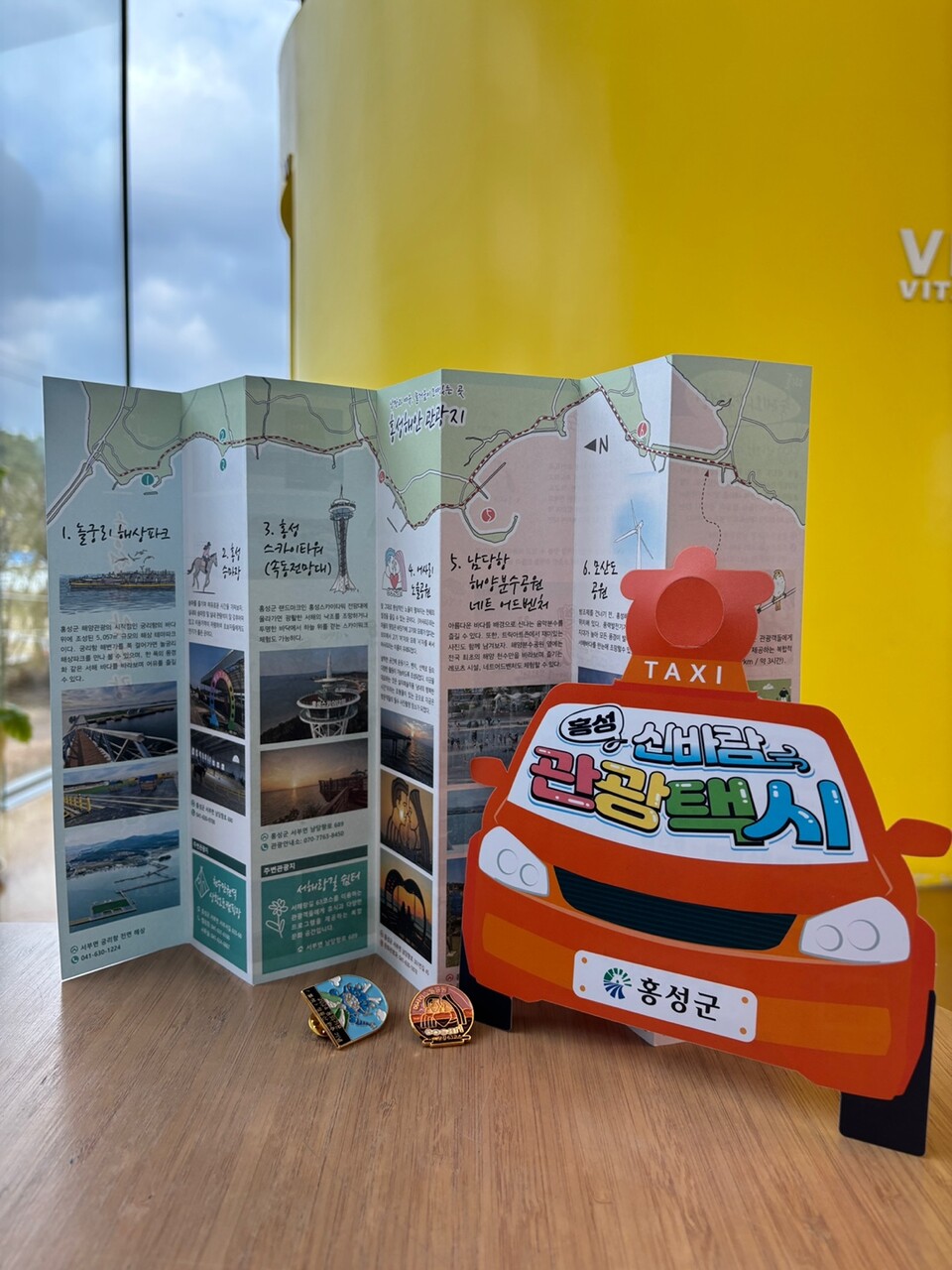 홍성 관광안내서와 신바람 관광택시 홍보물, 그리고 서해랑길 인증 배지. 주영석 인턴기자