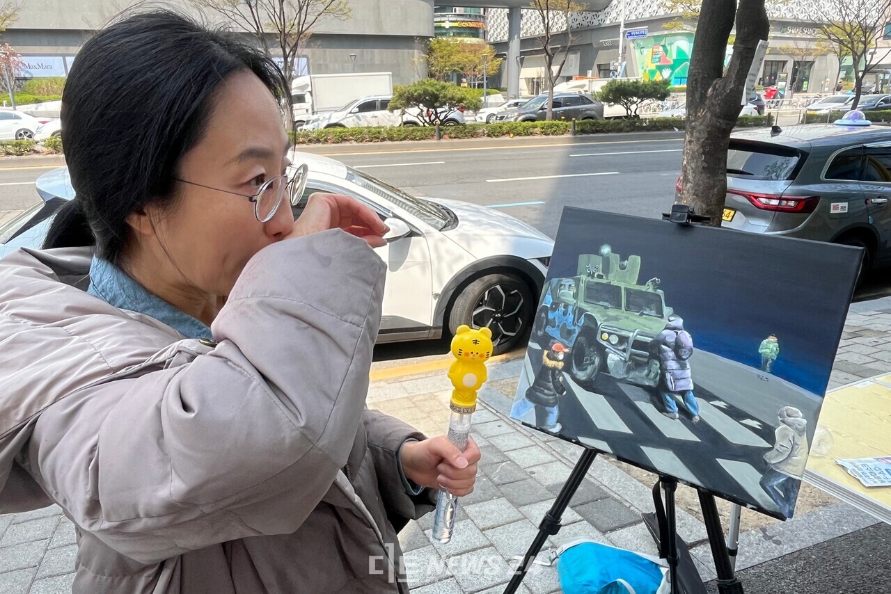 김나희 씨가 자신의 그림 '내란의 밤'을 지켜보며 울고 있다. 유솔아 기자.