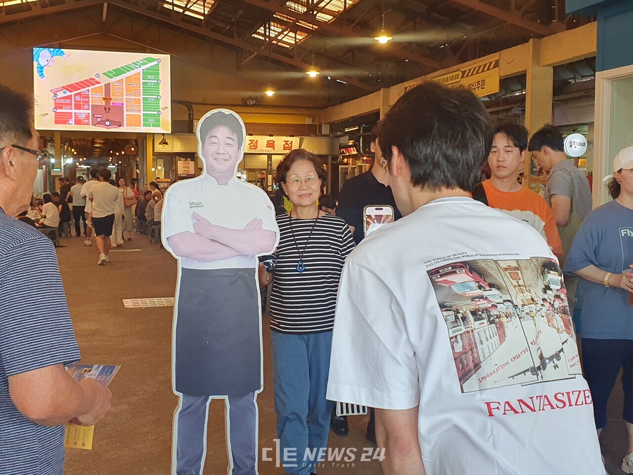 예산시장 내 설치된 '백종원 대표'의 입간판 앞에서 방문객들이 기념사진을 찍고 있다. 디트뉴스DB. 