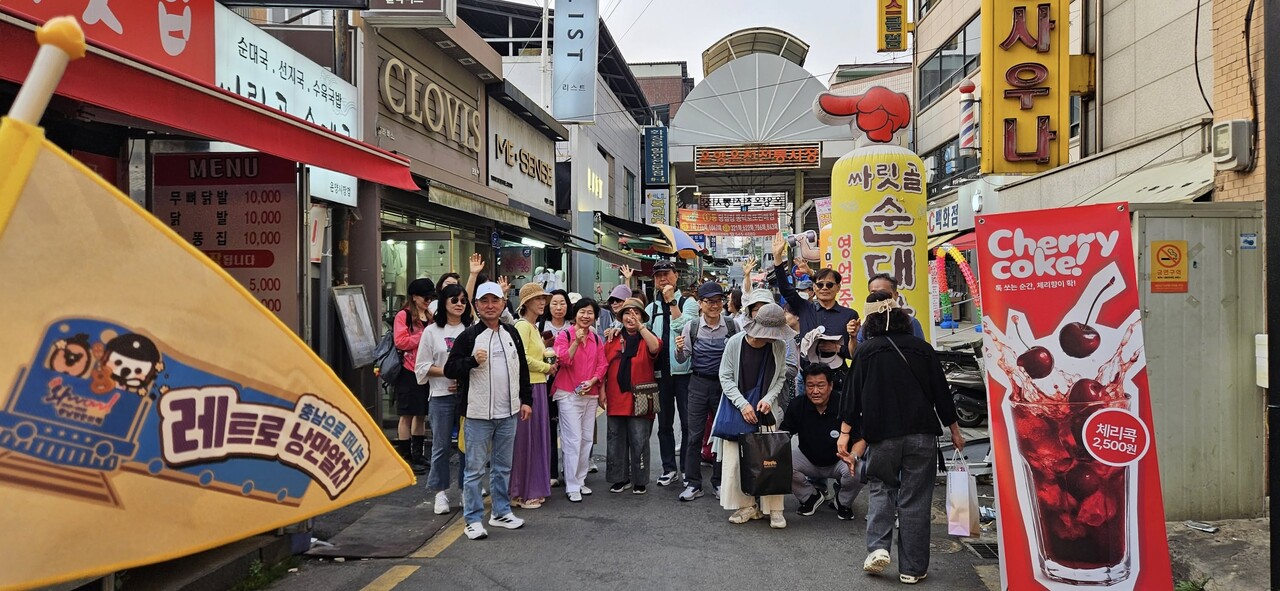 충남레트로낭만열차 참가자들이 온양 전통시장 인근에서 하루 일정을 마무리하며 기념 사진을 찍고 있다. 충남문화관광재단 제공. 