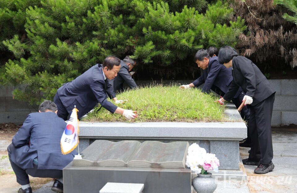 27일 서천군의회 의원들이 한산면 종지리에 위치한 독립유공자 김갑수 지사의 묘소를 찾아 주변을 정비하고 있다. /서천군의회