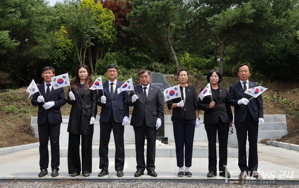 27일 독립유공자 김갑수 지사의 묘소를 찾은 충남 서천군의회 의원들이 태극기를 든 채 기념촬영을 하고 있다. /서천군의회