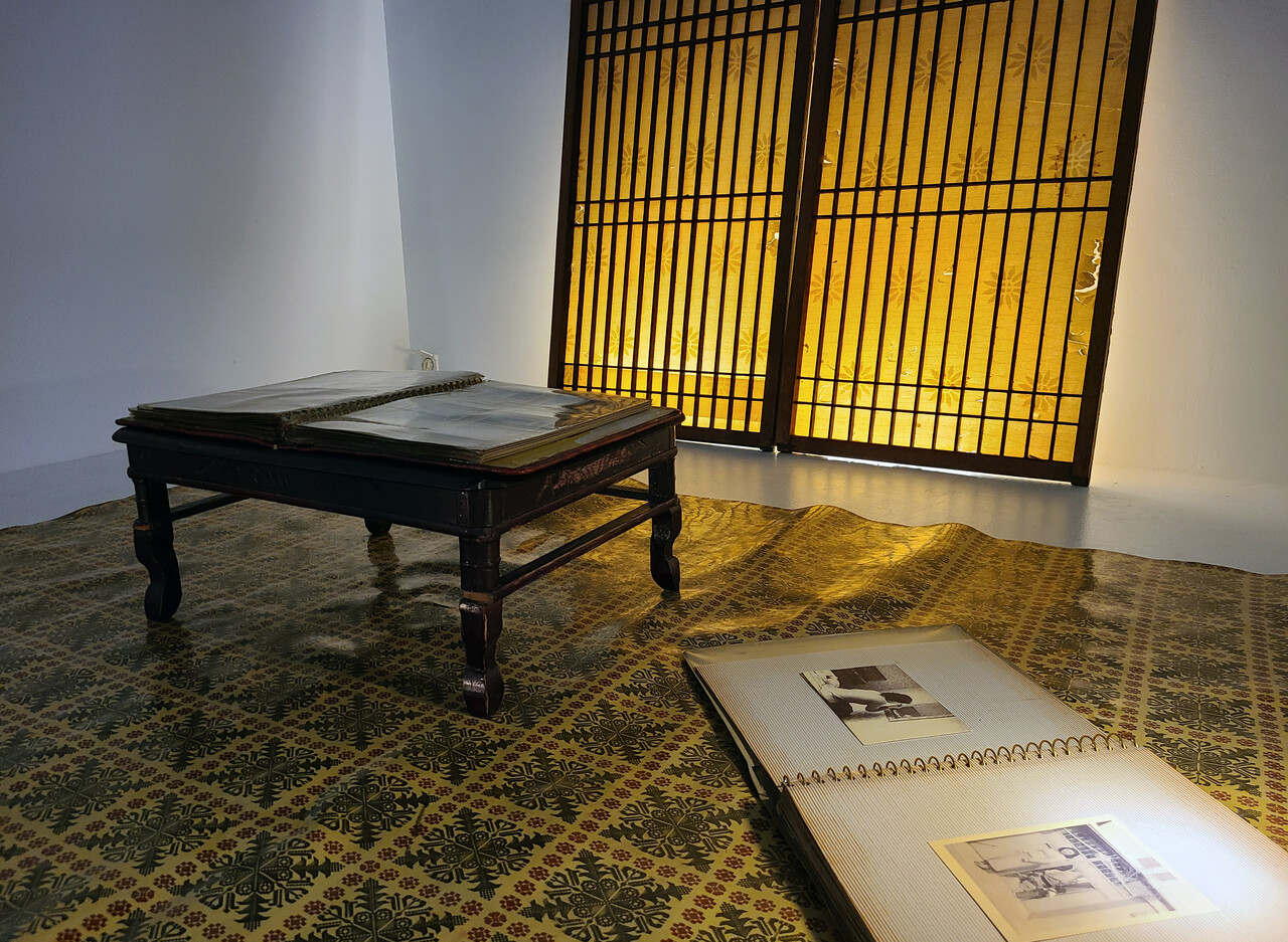 전시장 한 쪽에 구현된 풍경. 화려한 옛 장판과 작은 탁상, 나무 창문과 흑백사진 앨범이 놓여있다. 한지혜 기자.