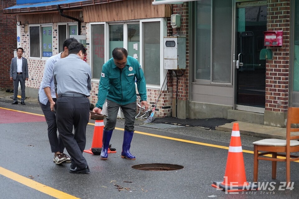 맨홀을 점검 중인 김기웅(오른쪽) 서천군수. /서천군