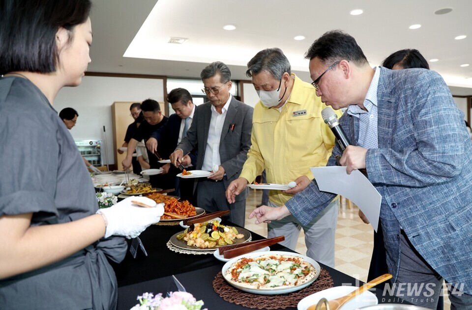 11일 열린 중간보고회에서 선보인 지역 특화자원 활용 ‘치유식단’을 가세로 군수 등 군 관계자들이 시식을 위해 음식을 담고 있는 모습. /태안군