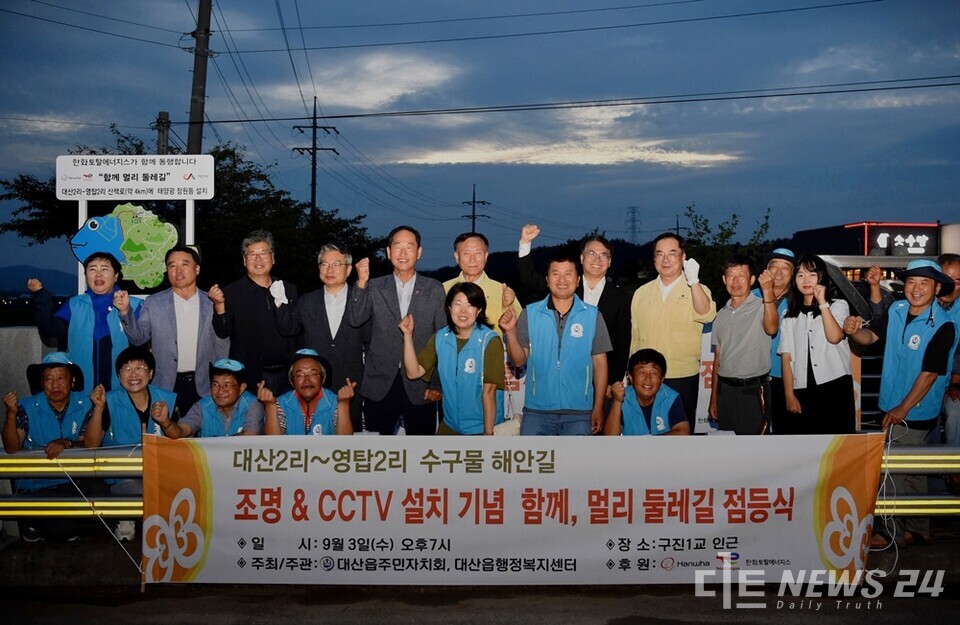한화토탈에너지스가 3일 충남 서산시 대산읍 수구물로 해안 산책로 입구에서 지역사회 관계자와 회사 임직원 등 30여 명이 참석한 가운데 ‘함께, 멀리 둘레길’ 점등식을 개최했다. 사진은 점등식 참석자들의 기념촬영 모습. /한화토탈에너지스
