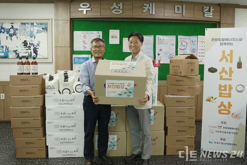 한화토탈에너지스가 서산지역 농수산물을 구매해 고객사에 전달하는 ‘서산밥상 데이’ 행사를 진행했다. 사진은 25일 한화토탈에너지스 관계자(오른쪽)가 고객사 ㈜우성케미칼 박병욱 대표이사(왼쪽)에게 농수산물을 전달하는 모습. /한화토탈에너지스